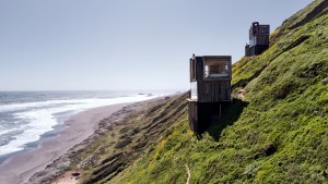 Dos cabañas enclavadas en una pendiente frente al paraíso del windsurf