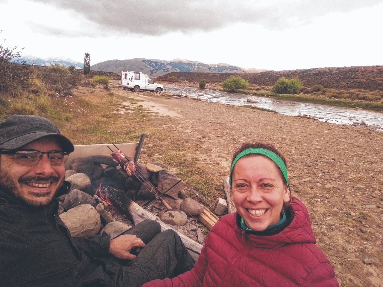 Pablo y Karen y un asadito en el río Centinela, cerca de El Calafate, Santa Cruz. Detrás, la ambulancia que transformaron en un camper para viajar y vivir a bordo. Los amigos la bautizaron "La Moscovita". 