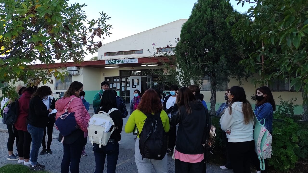 Desde primera hora de hoy, alumnos y padres-madres esperan el dialogo con las autoridades de la escuela -en la vereda- para que sus hijos vuelvan a tener clases. Foto gentileza