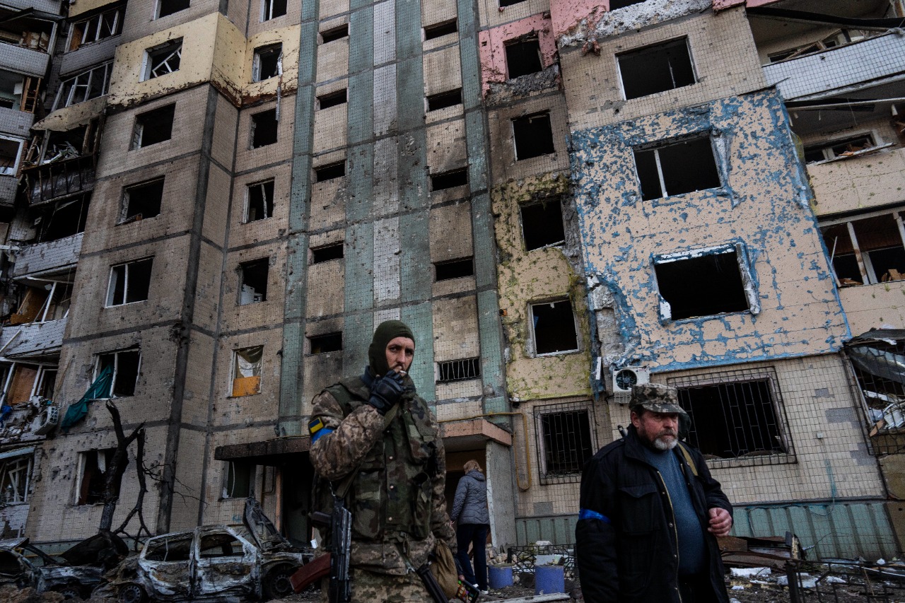 Un soldado fuma un cigarrillo mientras camina junto a un edificio destruido tras un bombardeo en el barrio de Satoya en Kiev.