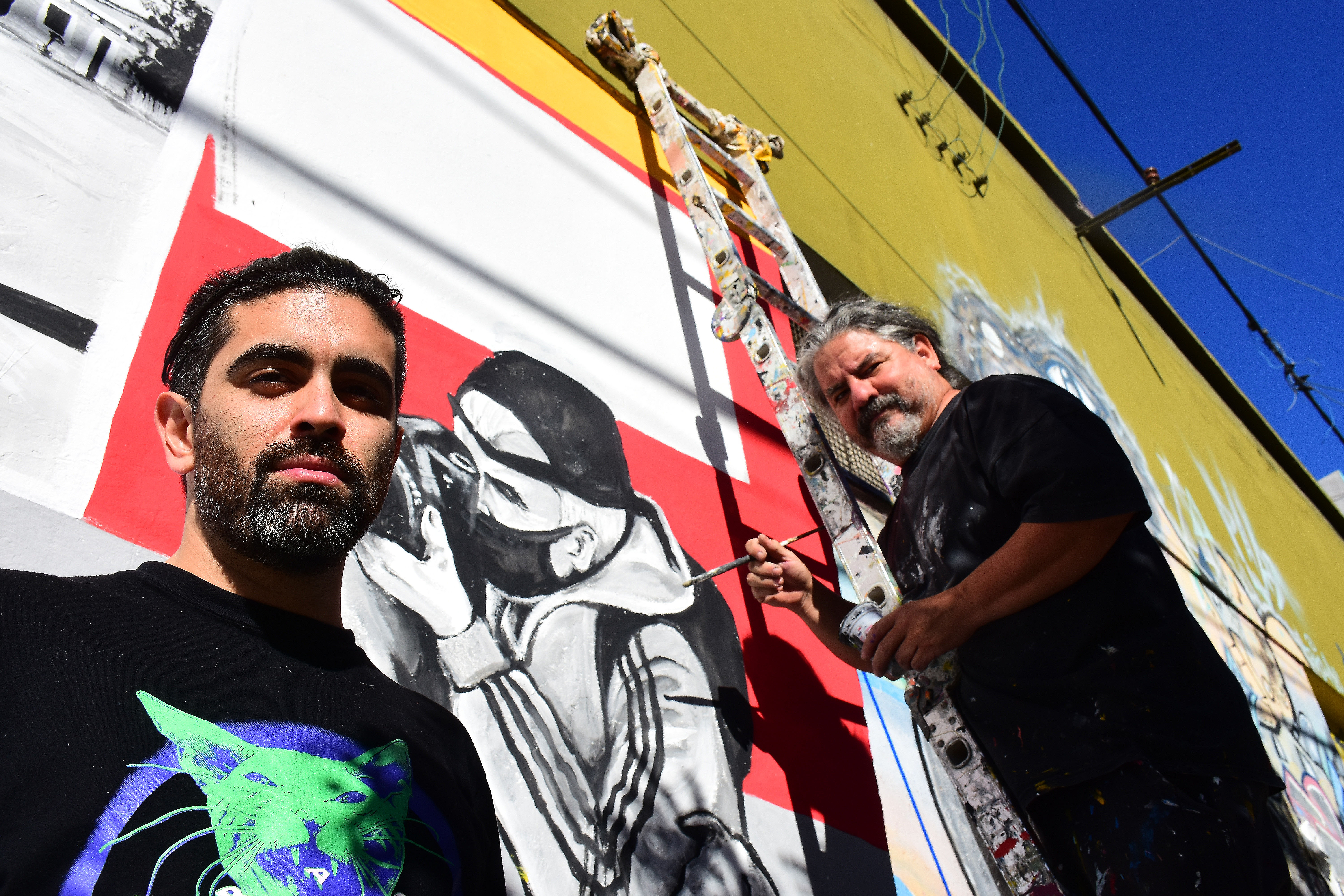 Joaquín, hijo de Adrián Alvarez, junto al creador del mural homenaje, el artista Chelo Candia. 