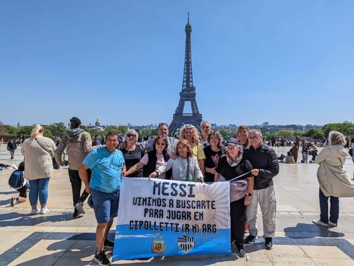 Claudio junto a su familia en Paris con la bandera que invita a Messi a jugar en Cipolletti. 