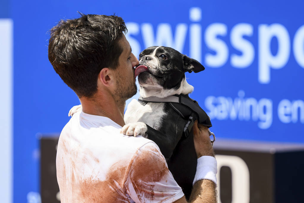 El campeón Pedro Cachín besa a su perro Tango tras derrotar a Albert Ramos-Viñolas en la final del Abierto de Suiza en Gstaad.  (Jean-Christophe Bott/Keystone vía AP)