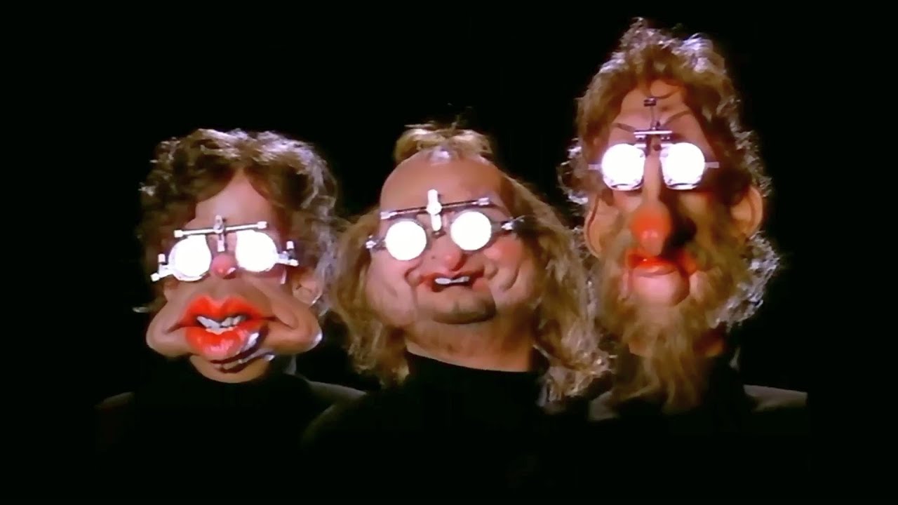 Tony Banks, Phil Collins y Mike Rutherford, caricaturizados con las máscaras del icónico videoclip de “Land of confusion”.