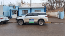 Imagen de Chocó contra el portón de una casa y un auto con una camioneta «melliza» en Cipolletti