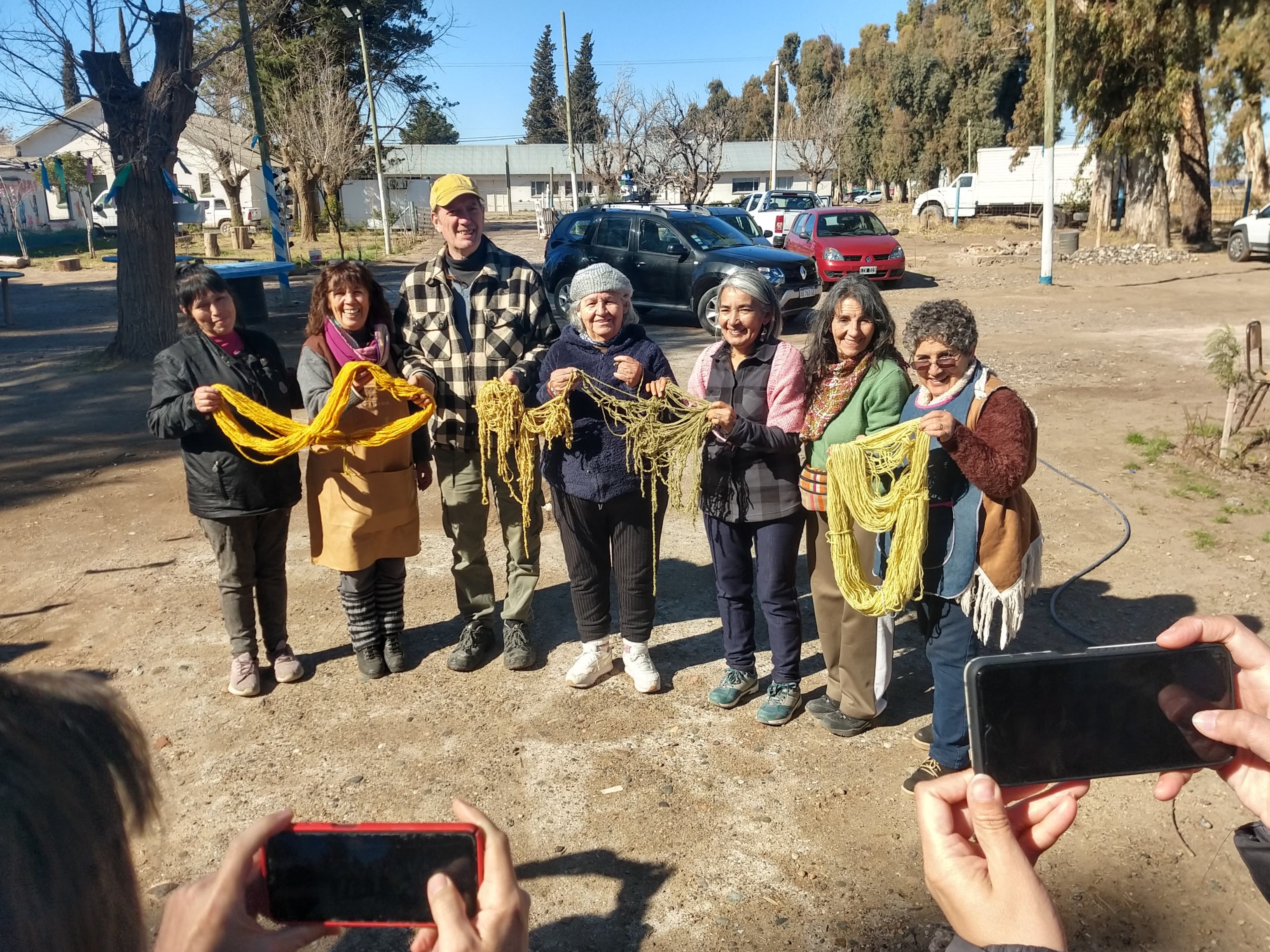 Elvia, con delantal y pañuelo morado al cuello, junto a parte del equipo que hace posible los talleres. 