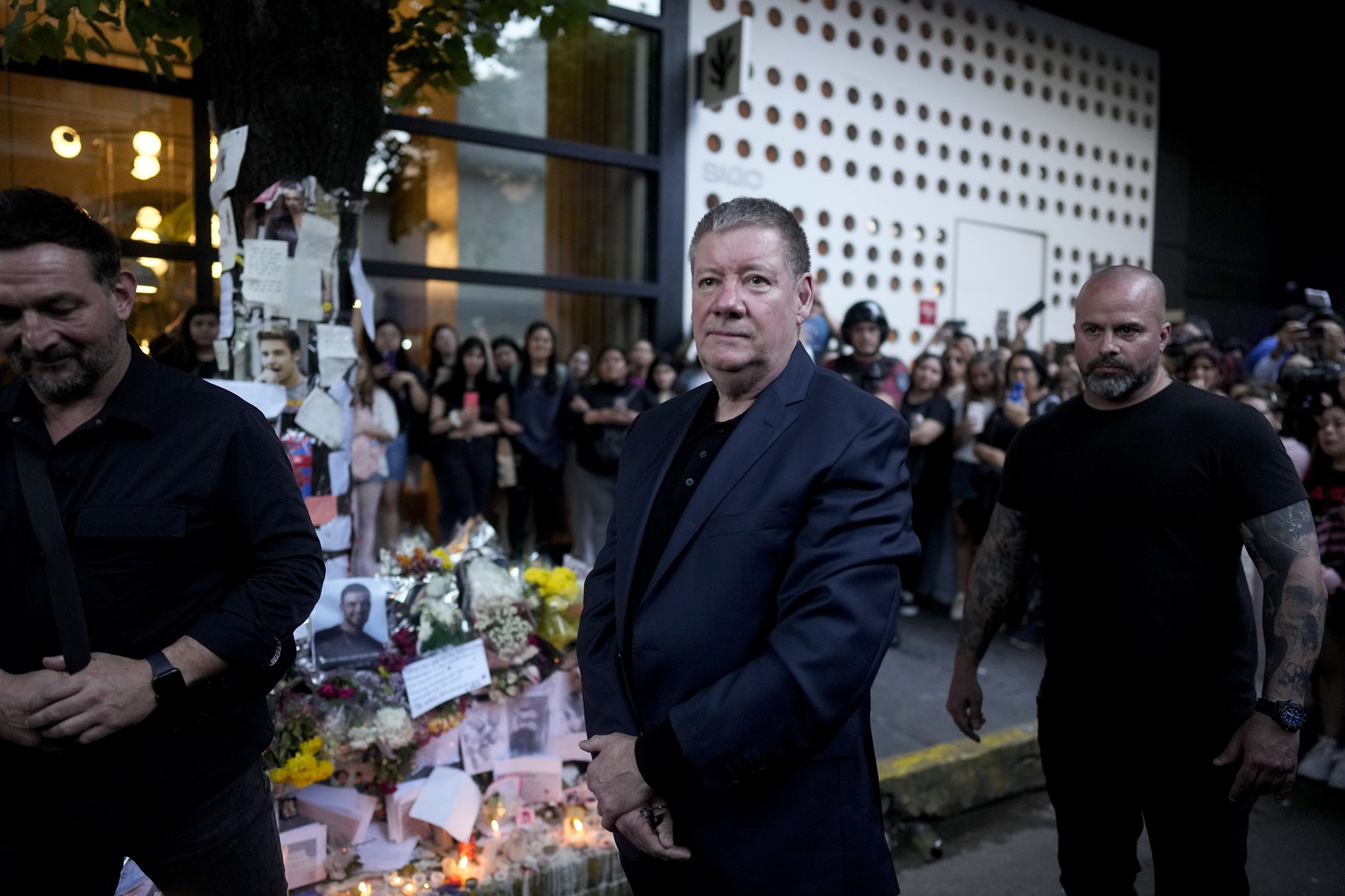 Geoff Payne, center, the father of former One Direction singer Liam Payne, visits the memorial for his son outside the Casa Sur Hotel where he fell to his death from a hotel balcony, in Buenos Aires, Argentina, Friday, Oct. 18, 2024. (AP Photo/Natacha Pisarenko)